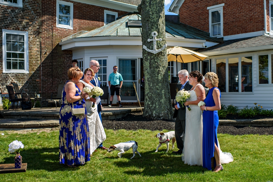 Two brides meet at the end of the isle with their parents.
